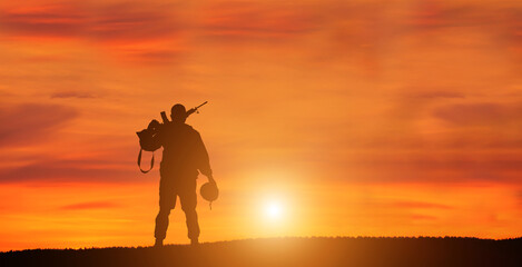 Fototapeta na wymiar Silhouette Of A Solider Saluting Against the Sunrise. Concept - protection, patriotism, honor.