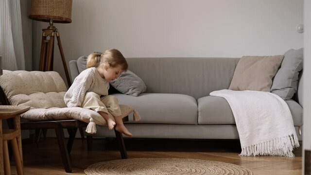 2 years old kid girl climb off  chair and walk away.