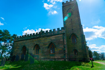 Fototapeta na wymiar Ancient church against blue sky with lens flare