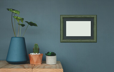 Photo frame Mockup Hanging on the Grey Wall. Surrounded by Green Plant in Vase and Pot. Decorative a House by Nature, Clean and Minimalist Style