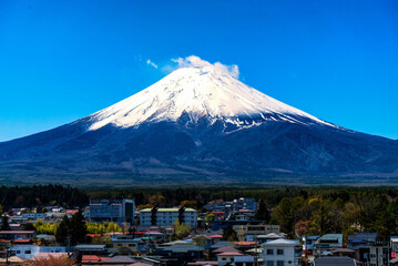 晴れた日の青空に映える富士山と裾野に広がる山梨県富士吉田市