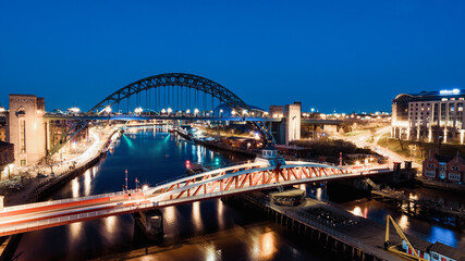 Fototapeta na wymiar Newcastle upon Tyne UK: 30th March 2021: Newcastle Gateshead Quayside at night, with of Tyne Bridge and city skyline, long exposure during blue hour