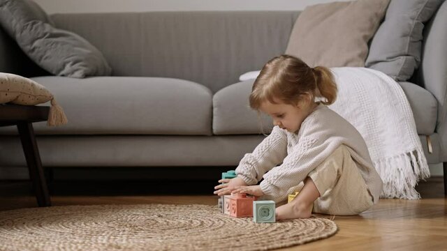 Litle cute child enjoy and concentrate playing colored  blocks, Slow Motion. Learning through play is an important part of a child&rsquo;s development. Child Development Concept.