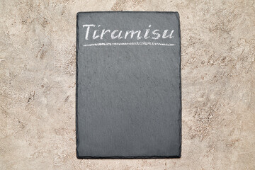 Stone serving menu board with chalk handwritten Tiramisu sign