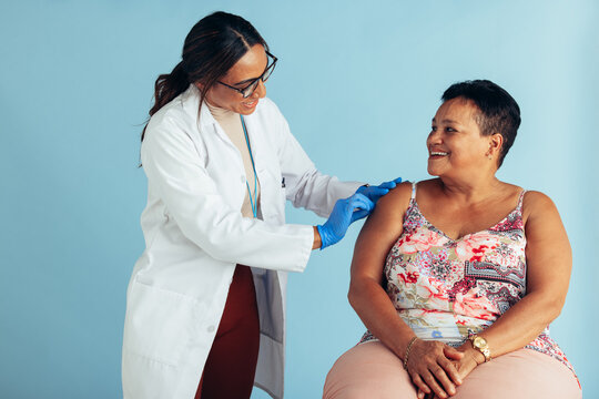 Doctor giving vaccine to senior patient