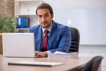 Fototapeta premium Young male employee sitting in the office in front of whiteboard