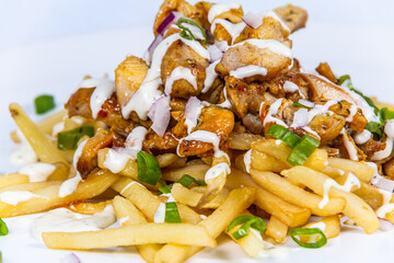 Fried french fries with pieces of turkey and onion. The food in the restaurant. Food styling and restaurant meal serving.