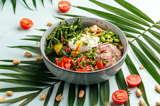 Bowl of roast beef pokeh with poached egg and vegetables
