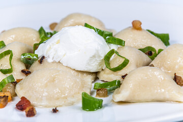 Potato dumplings with bacon and spring onions. The food in the restaurant. Food styling and restaurant meal serving.
