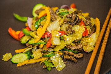 Beef pieces of meat with grilled vegetables on the Chinese way. The food in the restaurant. Food styling and restaurant meal serving.