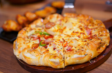 scooping hawaiian half deluxe pizza dough thick and soft cheese to burger edge with white and black sesame on tray with grilled chicken drumstick barbecue to family eating at italian food restaurant