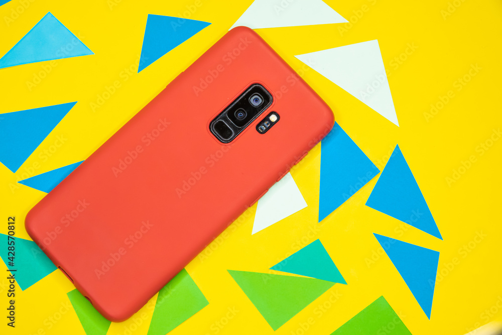 Poster top view of a red mobile phone on a yellow surface surrounded by triangles
