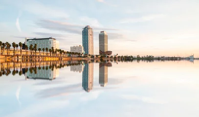 Fotobehang Barcelona Amazing reflection of the famous tower of Barcelona, Hotel Arts and Mapfre Tower, in front of the beach during a sunny day in Barcelona, Spain.  © Maxim Morales