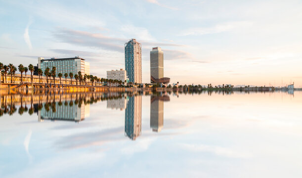Amazing reflection of the famous tower of Barcelona, Hotel Arts and Mapfre Tower, in front of the beach during a sunny day in Barcelona, Spain.