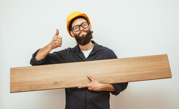 Cheerful worker - craftsman in work clothes with floor laminate in hands insulated on studio background. Collage in magazine style. Flyer with trendy colors, copyspace for ad. Your text here.