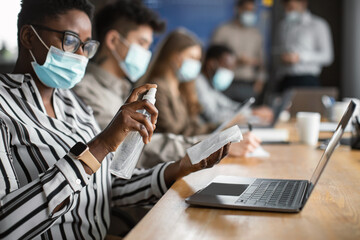 International people wearing medical masks using sanitizer