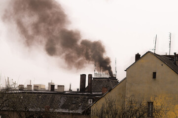 Black smoke from the chimney of the house.