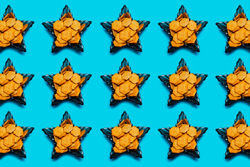 Pattern of spicy crackers in glass bowls in shape of star on blue background.