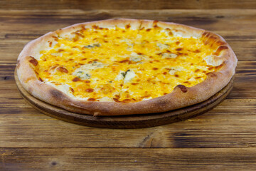 Pizza Four cheese on a wooden background