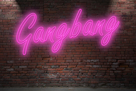 Neon Gangbang lettering on Brick Wall at night