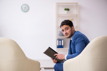 Young male employee waiting for business meeting