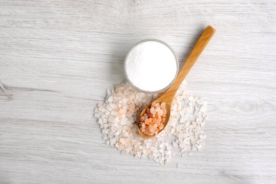 
Colorful rock salt in wooden spoon on a white background