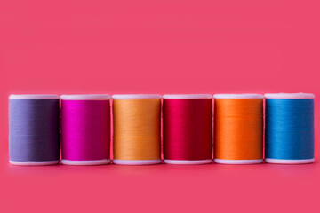 Color sewing threads on pink background