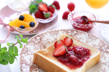 Delicious toast with strawberry jam, fresh strawberry and butter.
Selective focus. いちごジャムトースト