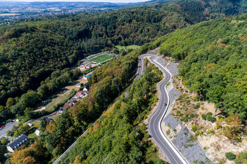 Fototapeta na wymiar Winding road serpentine from a high mountain pass in the rhine village Bendorf Sayn Germany Aerial view