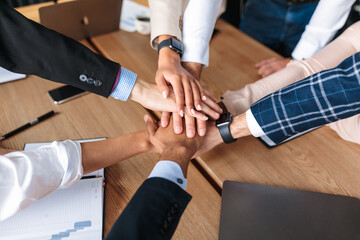 Fototapeta premium Top-View Of United Business Team Holding Hands In Office