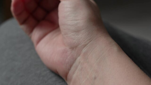 Closeup view 4k stock video footage of female adult hand with visual visible pulsing blood pressure under skin of wrist