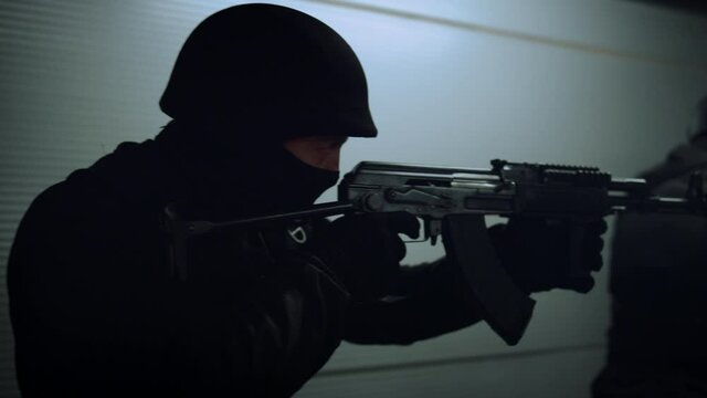 SWAT officers aiming rifles. Special ops police squad covering territory 