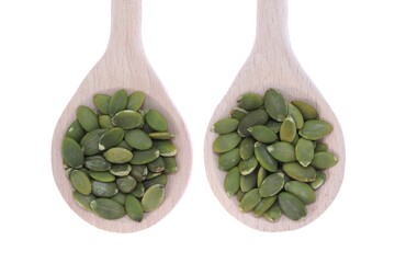 pumpkin unshelled seeds in wooden spoons