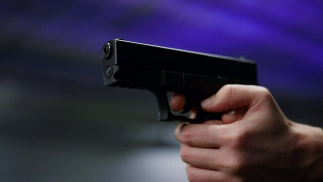Male hands holding loaded gun. Policeman arms shooting with weapon