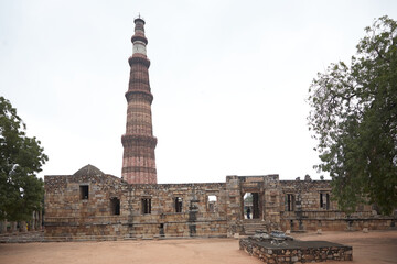 Fototapeta na wymiar The Qutb Minar is a victory tower, watchtower and minaret in the Qutb complex in Delhi. Daylight. Eye-level. 