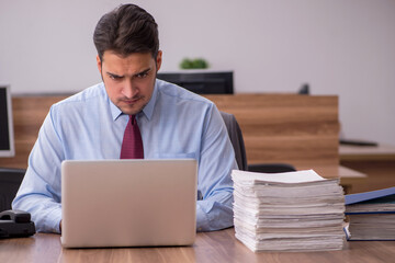 Young male employee unhappy with excessive work in the office