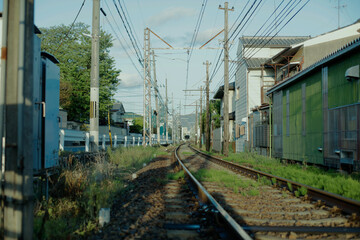 Fototapeta na wymiar Railway tracks in the morning. Electrical wire and cables. Local tram train tracks in Kyoto, Japan.