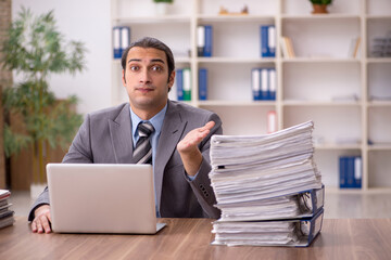 Young male employee unhappy with excessive work in the office