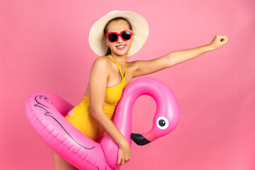 Beautiful, Sexy asian woman in  bikini and smiling standing on pink background isolated .Summer vocation happy trip concept.