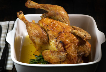 Roast chicken on a white plate, on a black wooden background. High quality photo