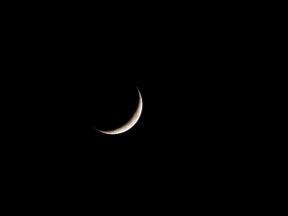Obraz na płótnie Canvas A waxing crescent moon with 11% illumination against a clear black sky as seen from Wakefield, West Yorkshire.
