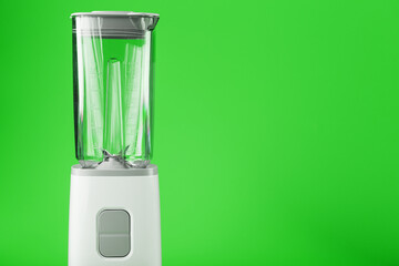 Electric blender with an empty jug on a green background.