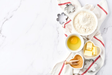 Baking background with flour, eggs, kitchen tools, utensils and cookie molds on white marble table. Top view. Flat lay style. Mock up.