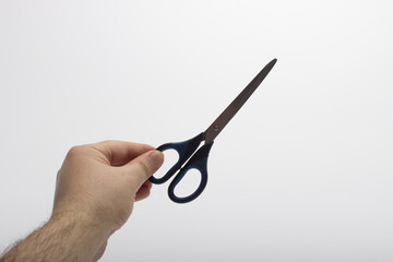 Hand is holding a scissors isolated on a white background. Stationery scissors in hand isolated on a white background.