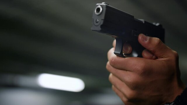 Policeman hands aiming gun. Male cop holding finger on trigger of pistol