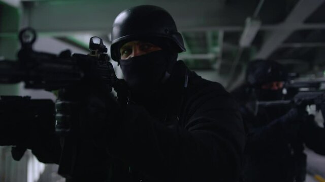 Anti terrorist squad looking through scopes on automatic rifles. SWAT police 