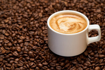 Cup of espresso coffee on Background made of roasted brown coffee beans