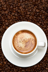 Cup of espresso coffee on Background made of roasted brown coffee beans