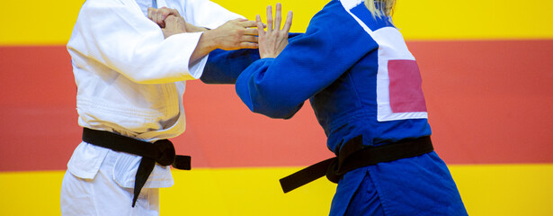 Two judo fighters in white and blue uniform. Professional sport concept