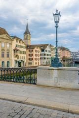 Naklejka premium Beautiful view of historic city center of Zurich with famous Fraumunster Church and Munsterbucke crossing river Limmat on a sunny day with blue sky and clouds in summer, Canton of Zurich, Switzerland